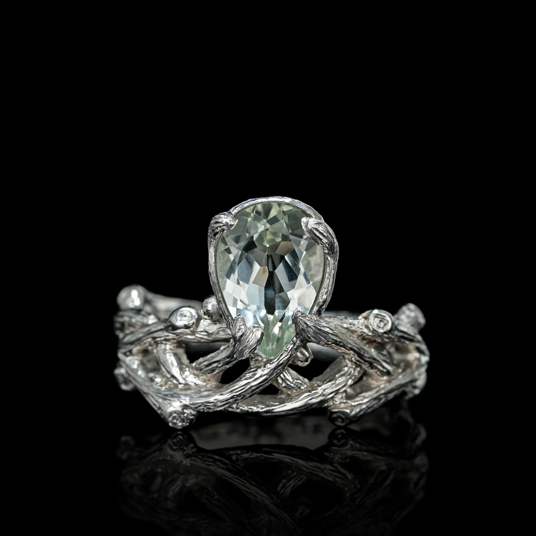 Verdant Grace ring with green amethyst centerpiece, sterling silver, and white rhodium plating against a black background.