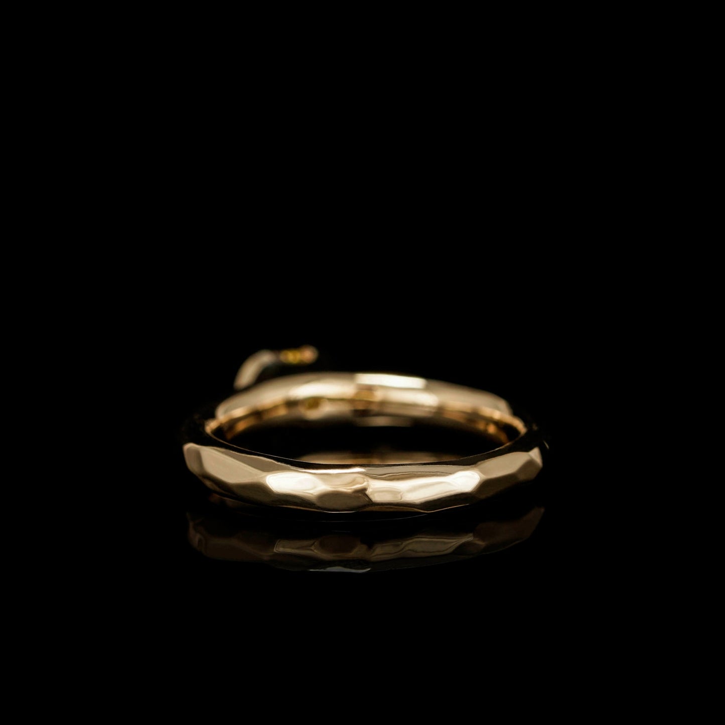 Elegant 18K yellow gold engagement ring with a faceted design on a black background.