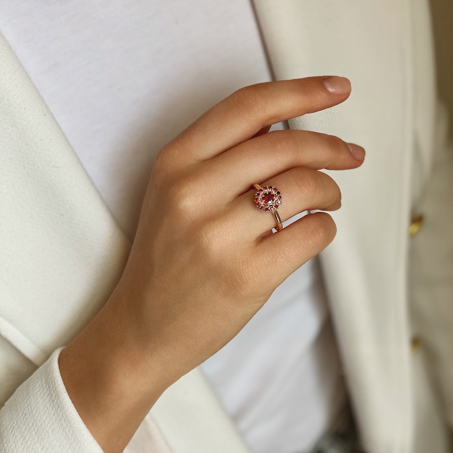 Elegant hand wearing Fiery Allure ring in red 14K gold with garnets, showcasing timeless beauty and luxury.