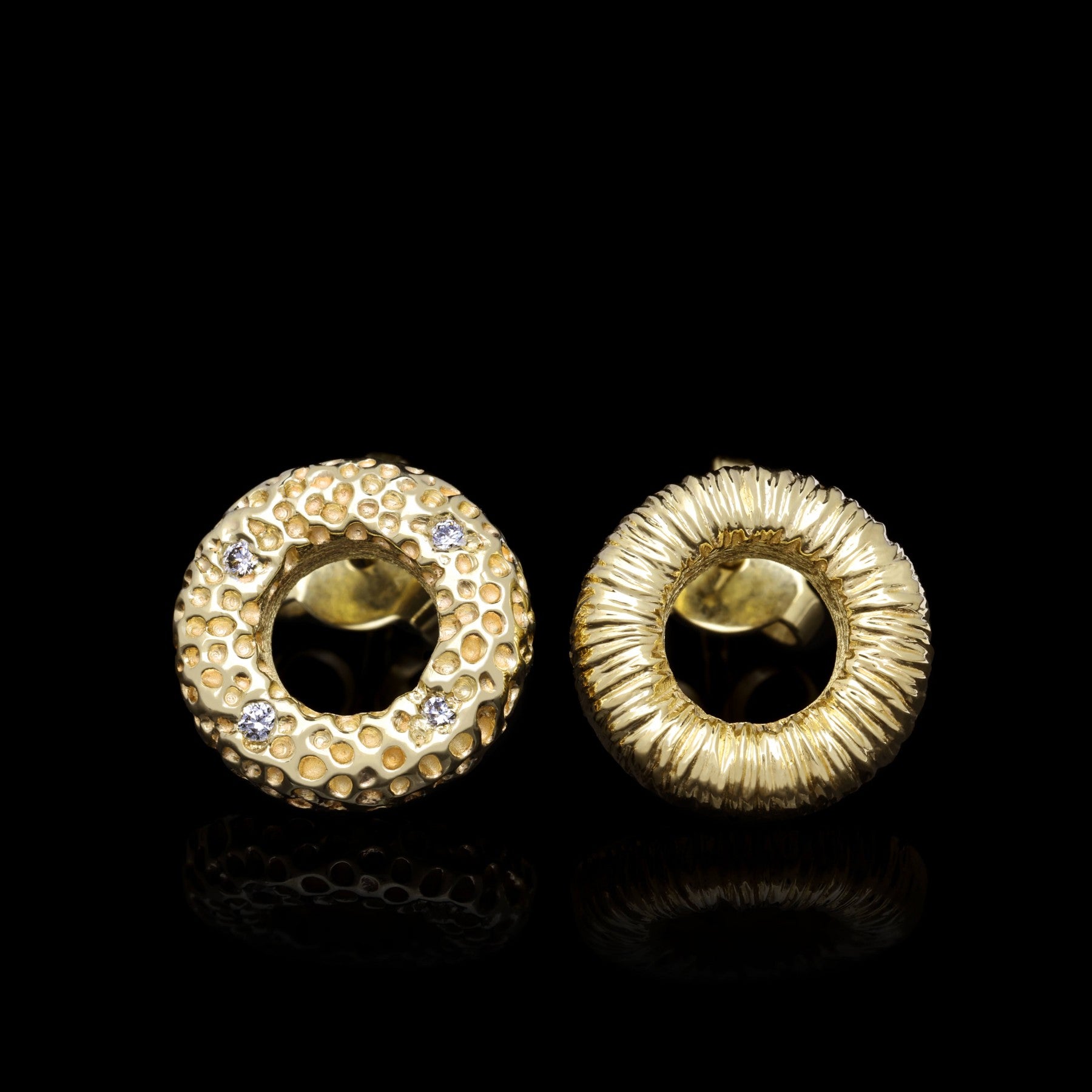 Celestial Glow golden stud earrings with 14K yellow gold, elegant texture, and four sparkling diamonds against a black background.