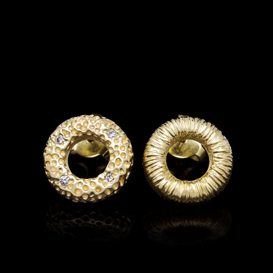 Celestial Glow golden stud earrings with 14K yellow gold, elegant texture, and four sparkling diamonds against a black background.