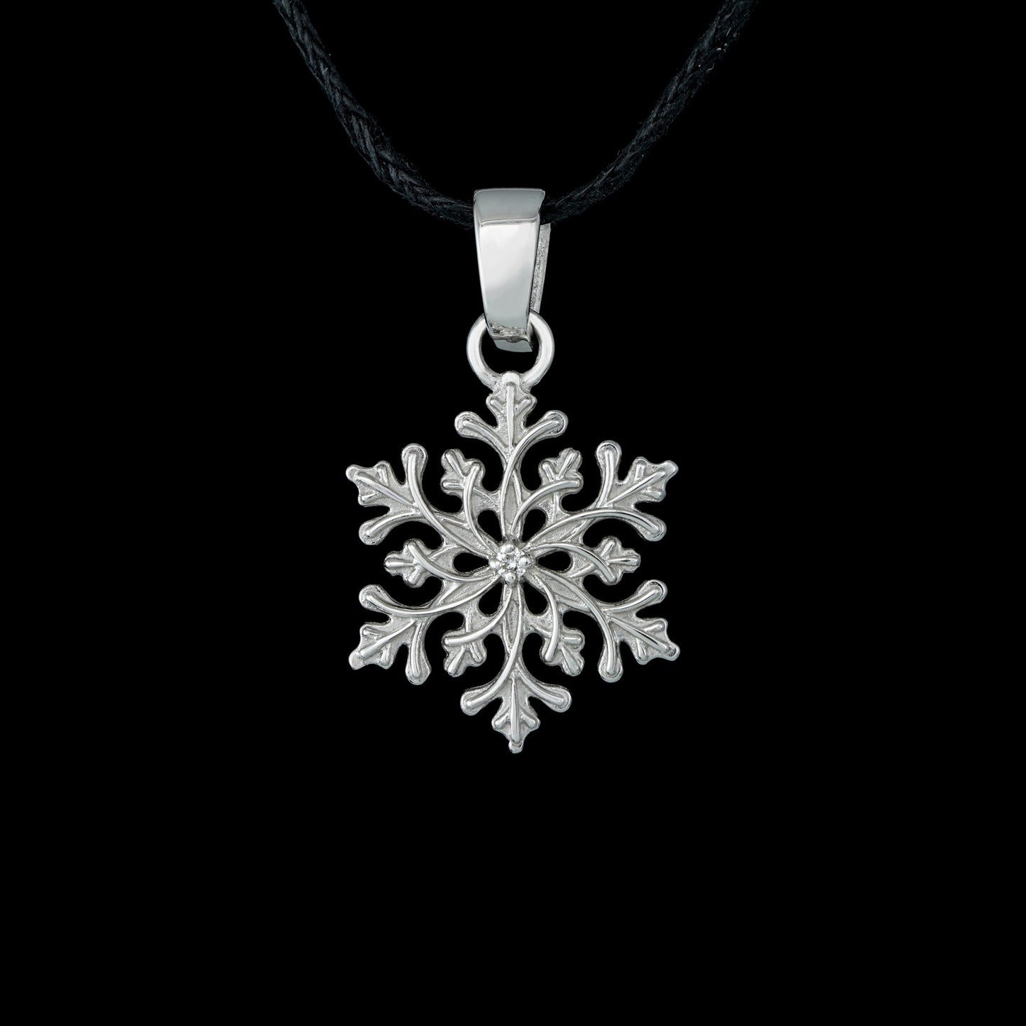 Sterling silver snowflake pendant "Winter’s Grace" with diamond, nature-inspired design on black background.