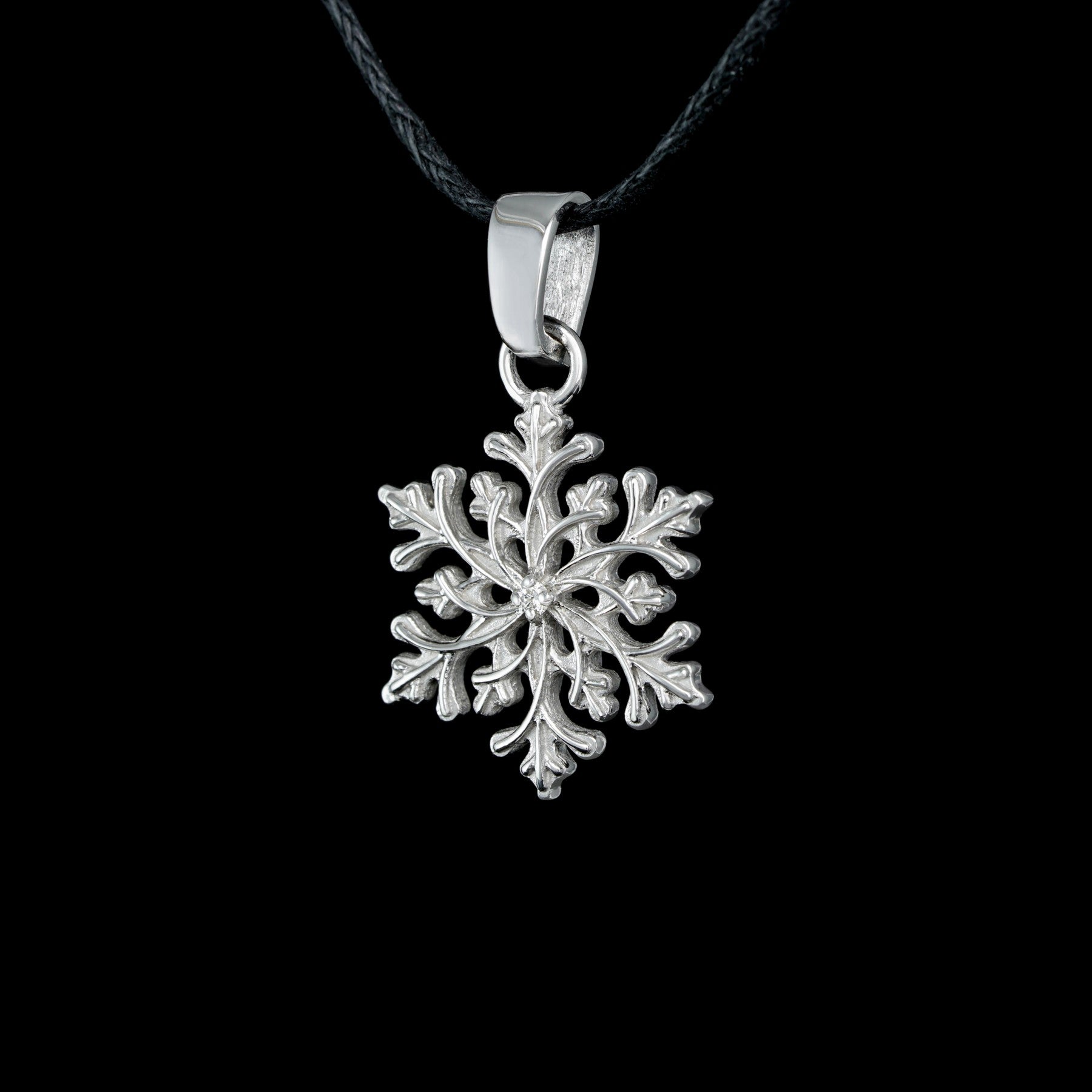 Sterling silver snowflake pendant "Winter’s Grace" with diamond detail on black cord, nature-inspired jewelry.