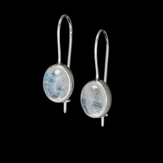 "Lunar Glow earrings with moonstones and 14K white gold, capturing celestial elegance against a black background."