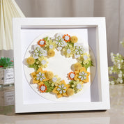Handmade quilted paper garland in a white frame, showcasing creative quilling craft with floral design for decorative use.