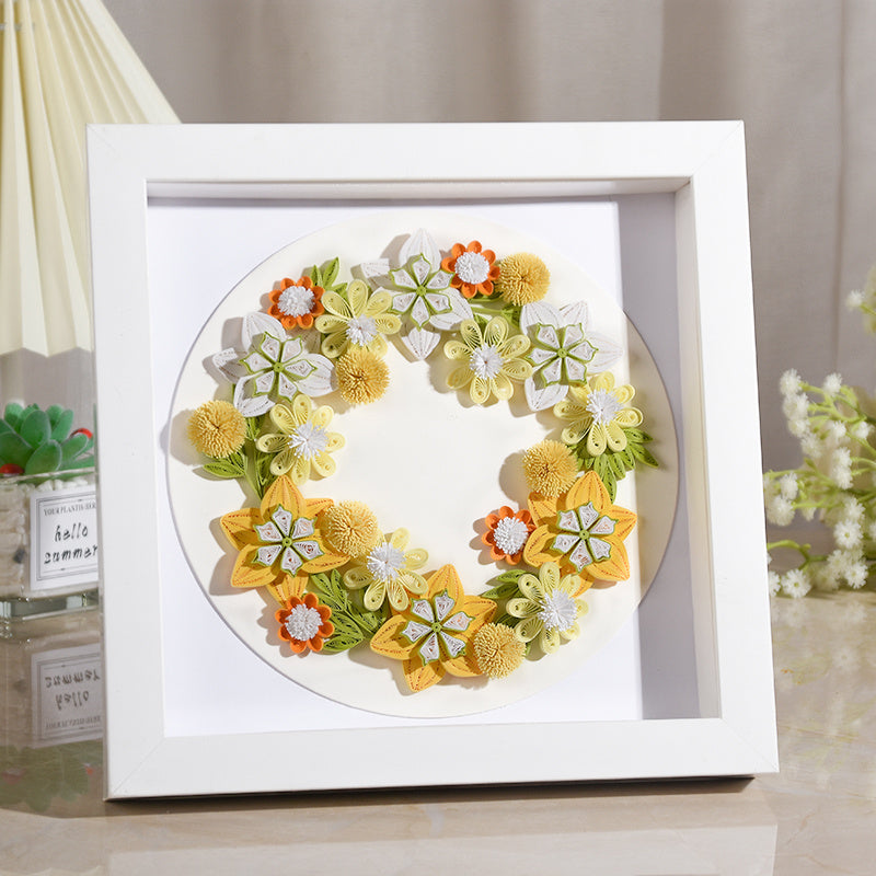 Handmade quilted paper garland in a white frame, showcasing creative quilling craft with floral design for decorative use.