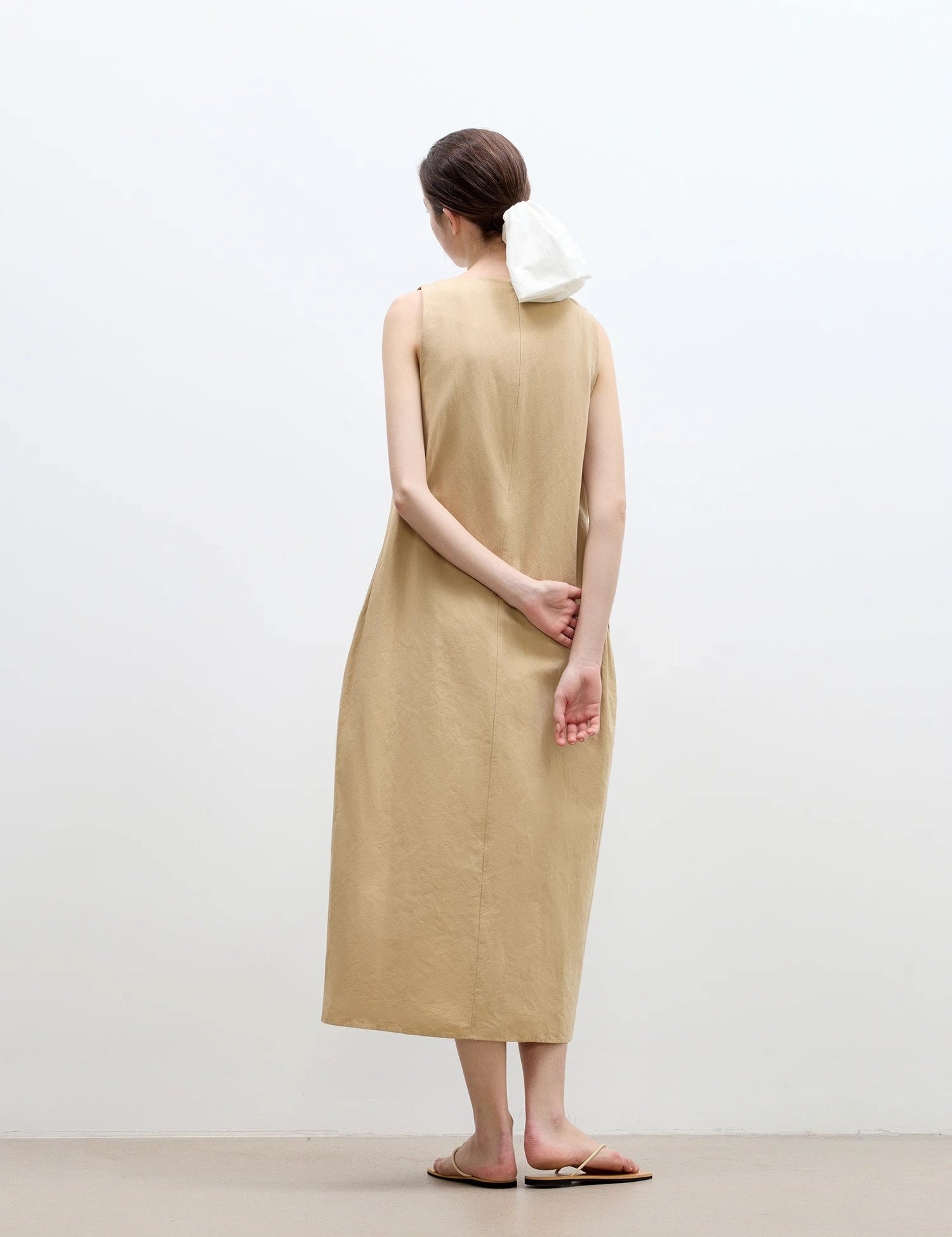 Woman wearing a khaki Serelis Cotton-Linen Hourglass Dress with a sleek, minimalist design and ankle-length hem in a neutral setting.