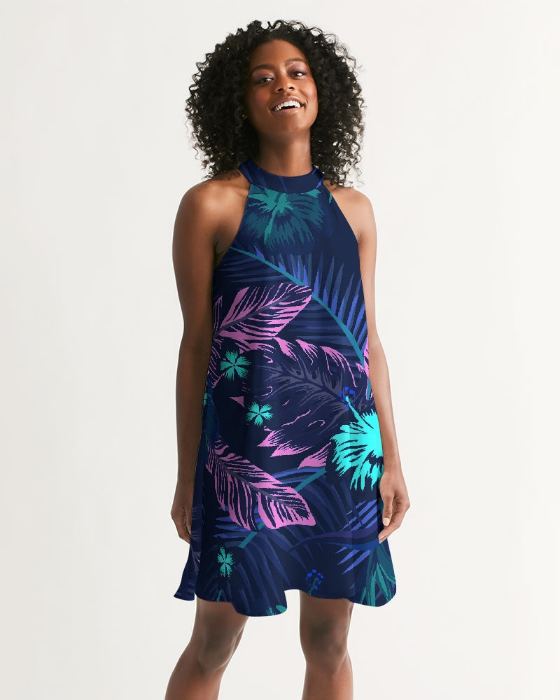 Woman wearing a Palm Drift halter dress with tropical leaf print, capturing the spirit of sun-drenched getaways and coastal elegance.