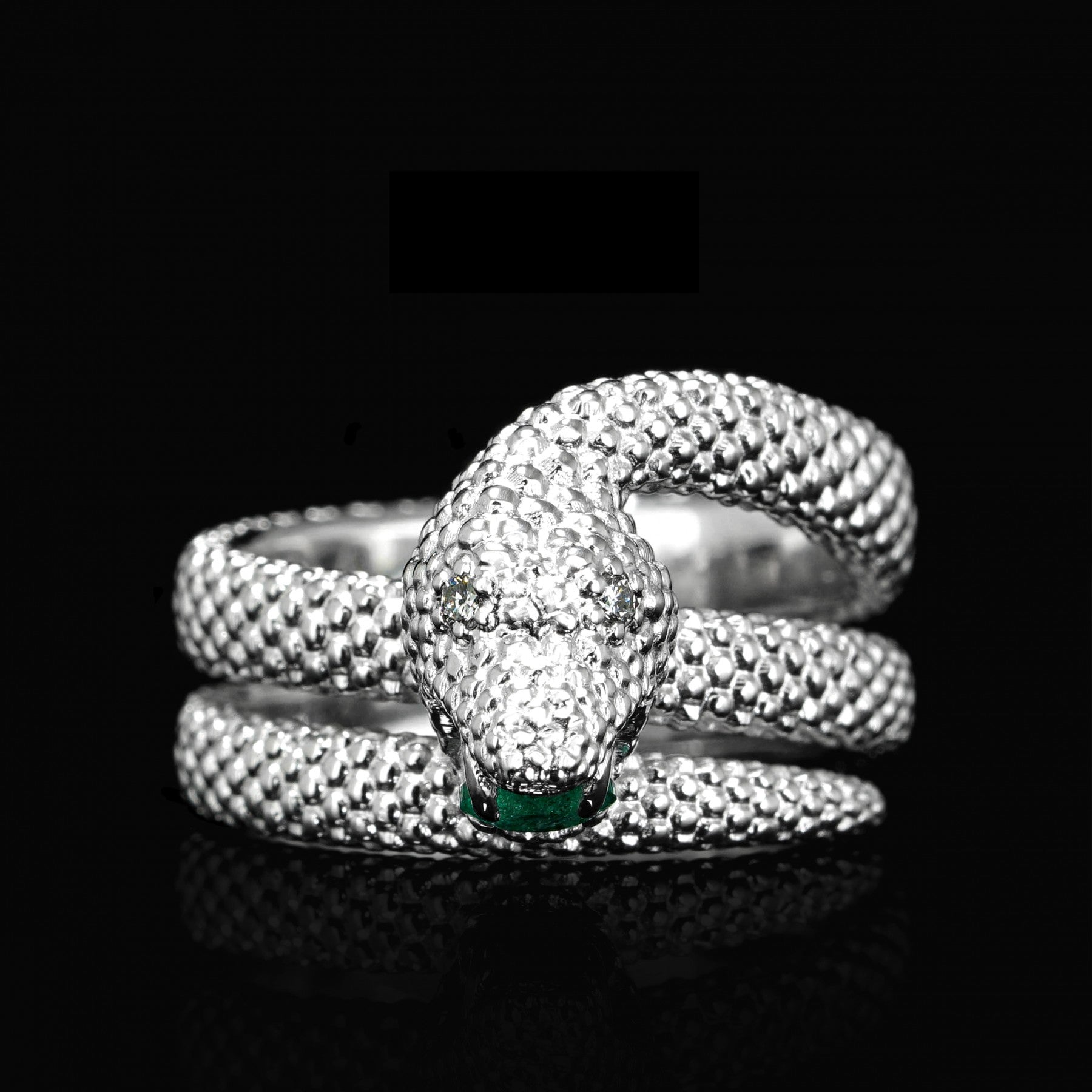 White gold serpent ring with emerald and diamonds, featuring an intricate snake motif symbolizing transformation and eternal love.