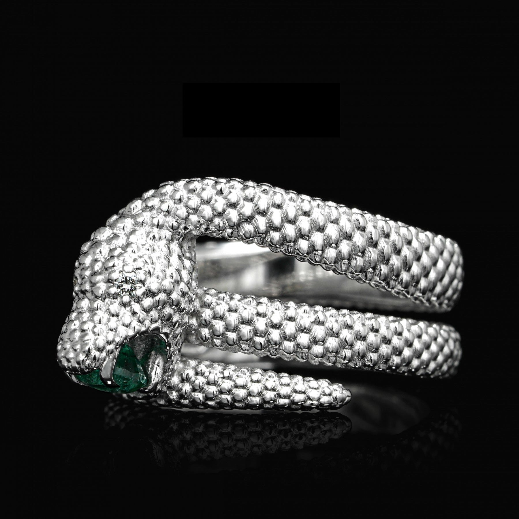 White gold snake ring "Serpent Symphony" with emerald and diamond accents, symbolizing transformation and eternal love.