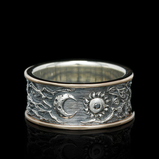 Intricately designed sterling silver ring with celestial moon and sun motifs, featuring a handcrafted, textured band on a black background.