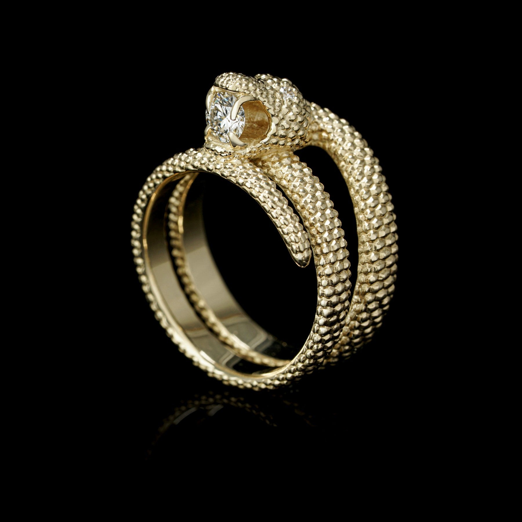 "Serpent Symphony ring in 14K yellow gold with diamond centerpiece and snake design, symbolizing wisdom and love"