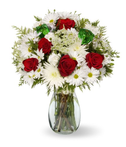 Festive Christmas bouquet with red roses, Fuji mums, pompoms, and green mist in a vase, spreading holiday cheer.