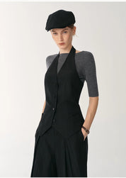 Model wearing a Solianne Silklinen Halter Vest in black, featuring a fitted waist, V neckline, and elegant sculpted shoulders.