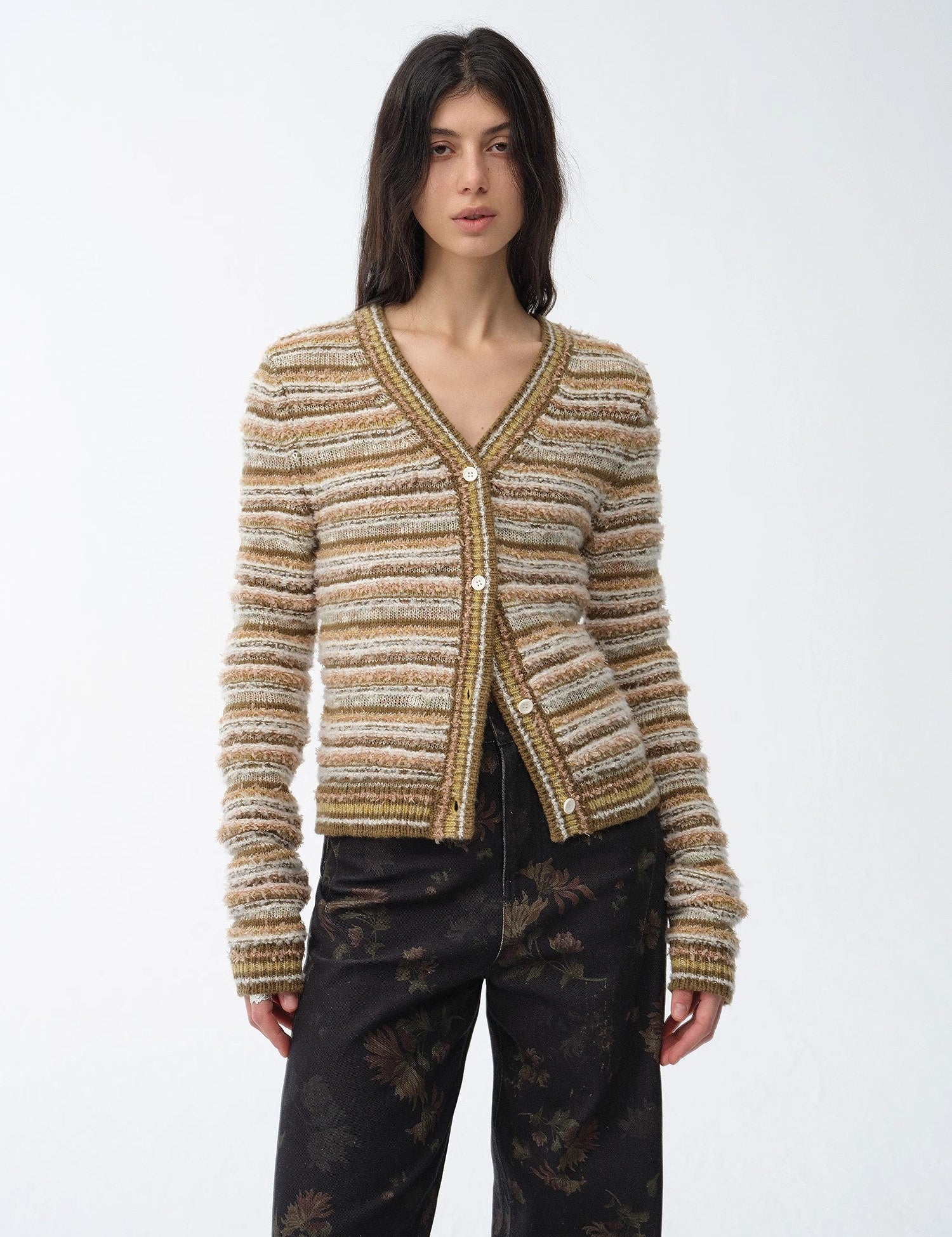 Woman wearing a Thalurea Stripeweave Vest, featuring a layered stripe pattern and V-neck design, blending texture and shimmer.