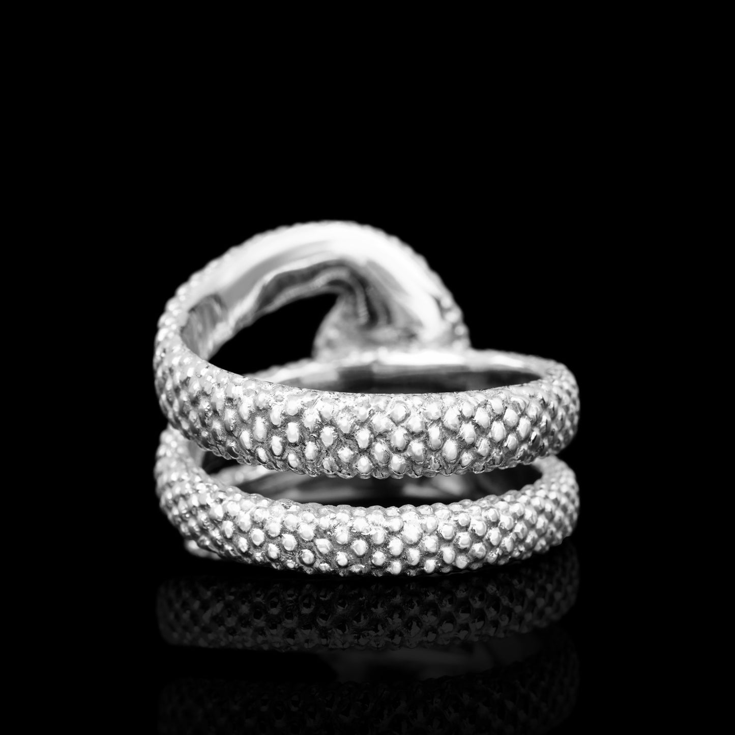 "Serpent Symphony" white gold ring with snake motif symbolizing transformation, crafted from 14K gold, on a black background.