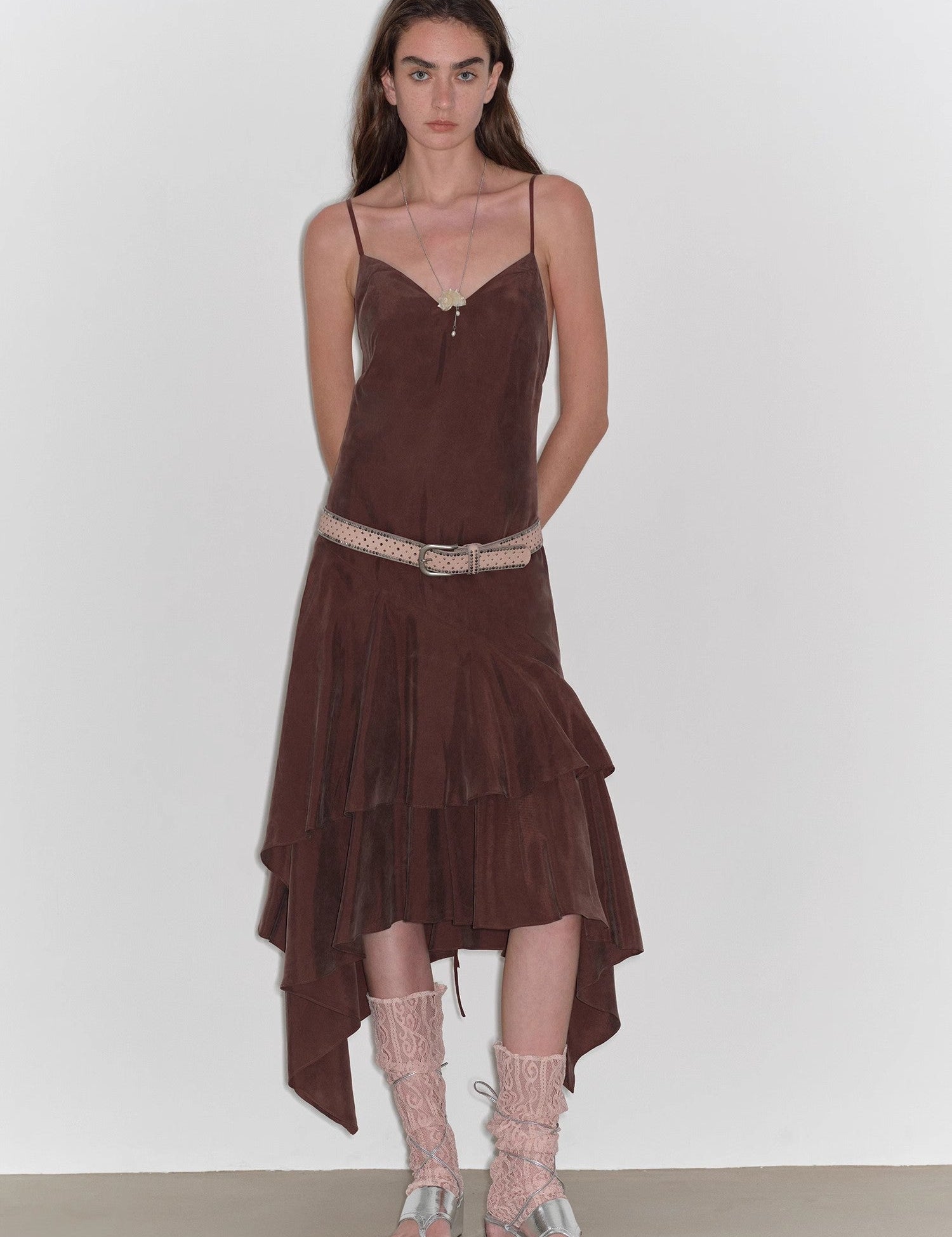 Model wearing Aravelle Draped Tie-Back Midi Dress in brown with asymmetric hem and V-neck, featuring delicate lace-up sandals.