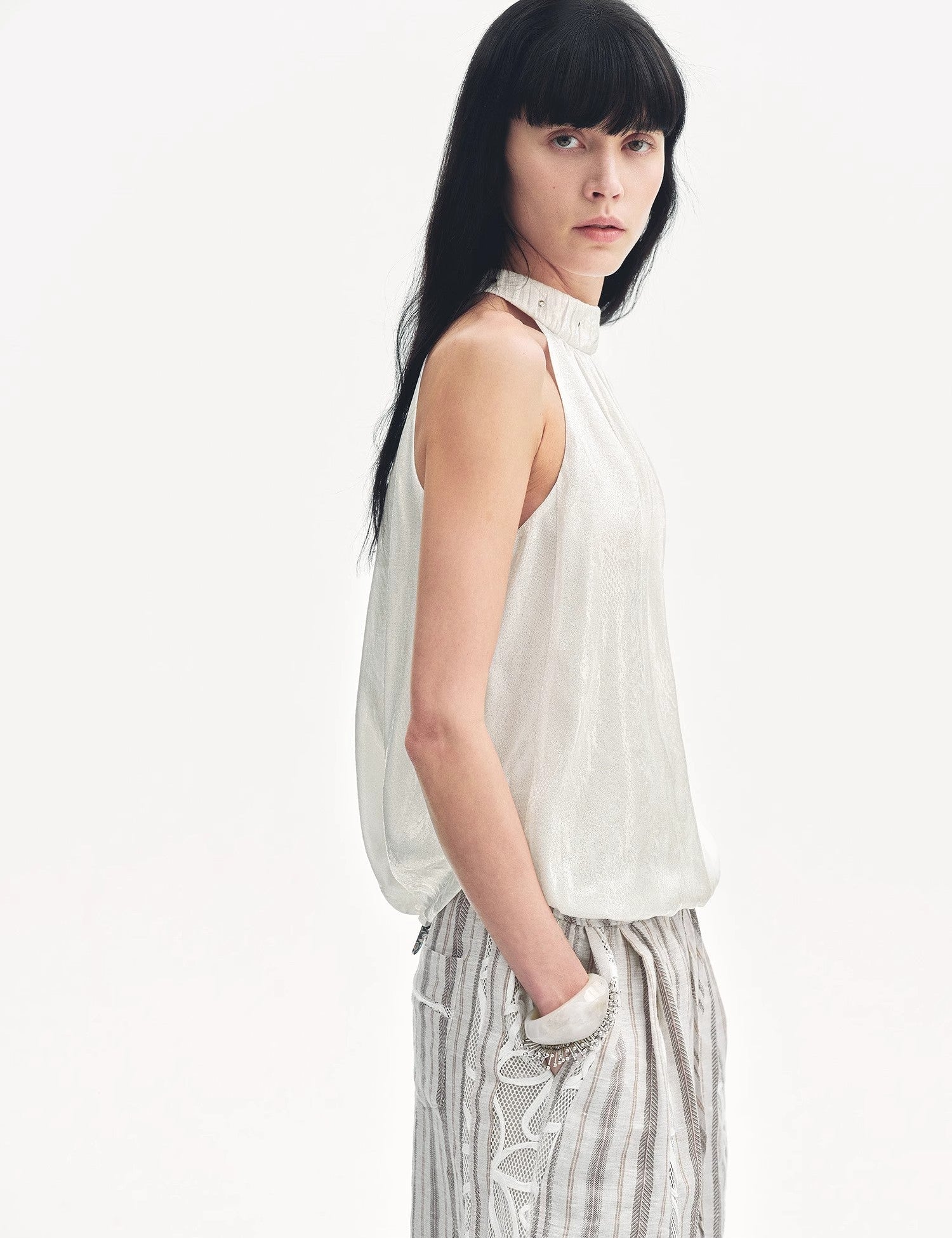 Model wearing Elireth Burnt-Floral Halter top with pleated A-line hem and petal-like textures by boutique atelier.