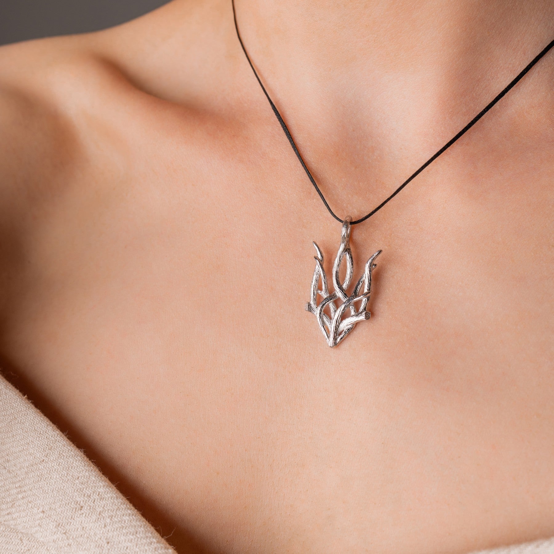 Woman wearing sterling silver Forest Trizub pendant necklace, symbolizing Ukrainian heritage with an oxidized finish.