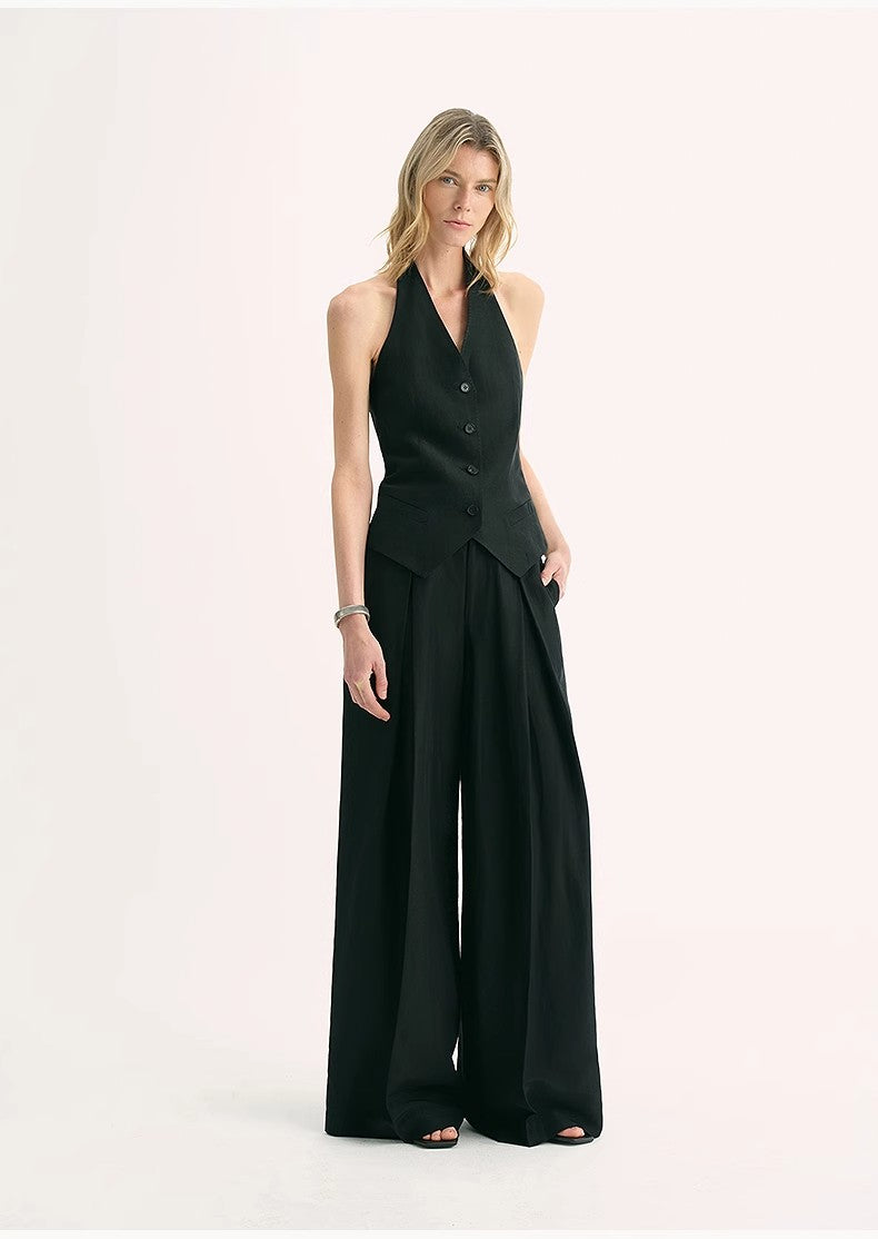 Woman wearing Solianne Silklinen Halter vest in black, featuring a V neckline and tailored cut, paired with wide-leg trousers.
