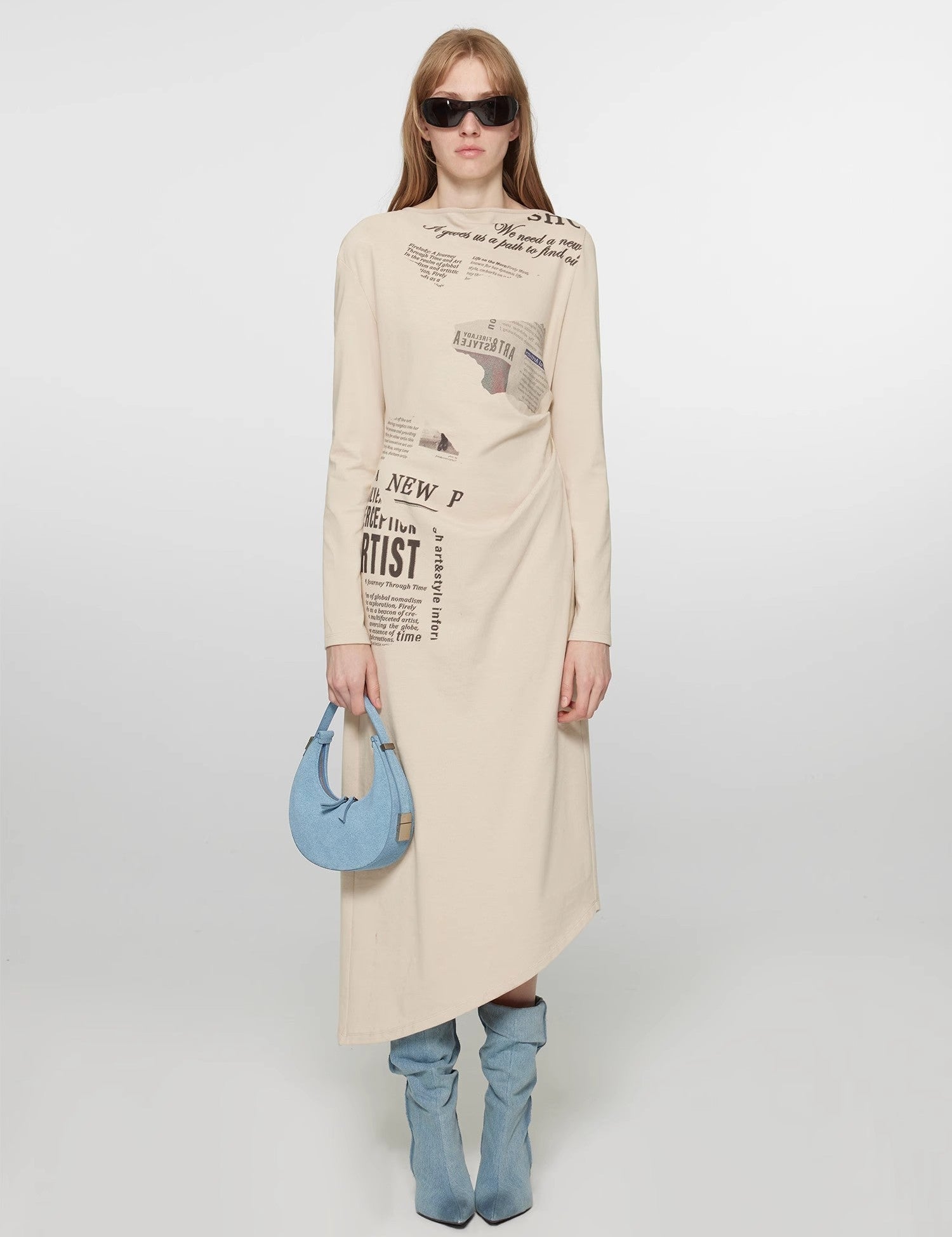 Model wearing City Frame Bias-Cut Dress with newspaper print, featuring a one-shoulder neckline and pleated waist for a vintage modern style.