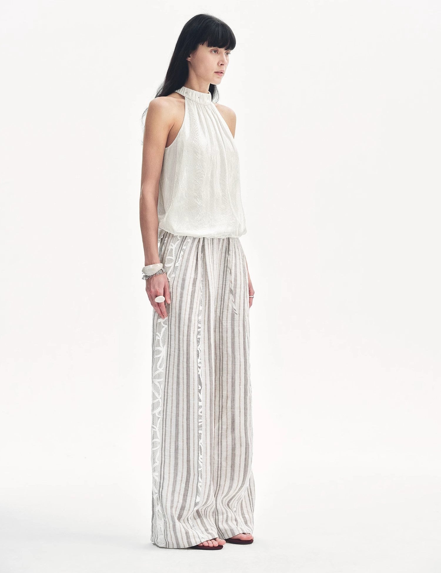 Model wearing Elireth Burnt-Floral Halter, showcasing a pleated A-line silhouette highlighting shoulders with petal-like textures.