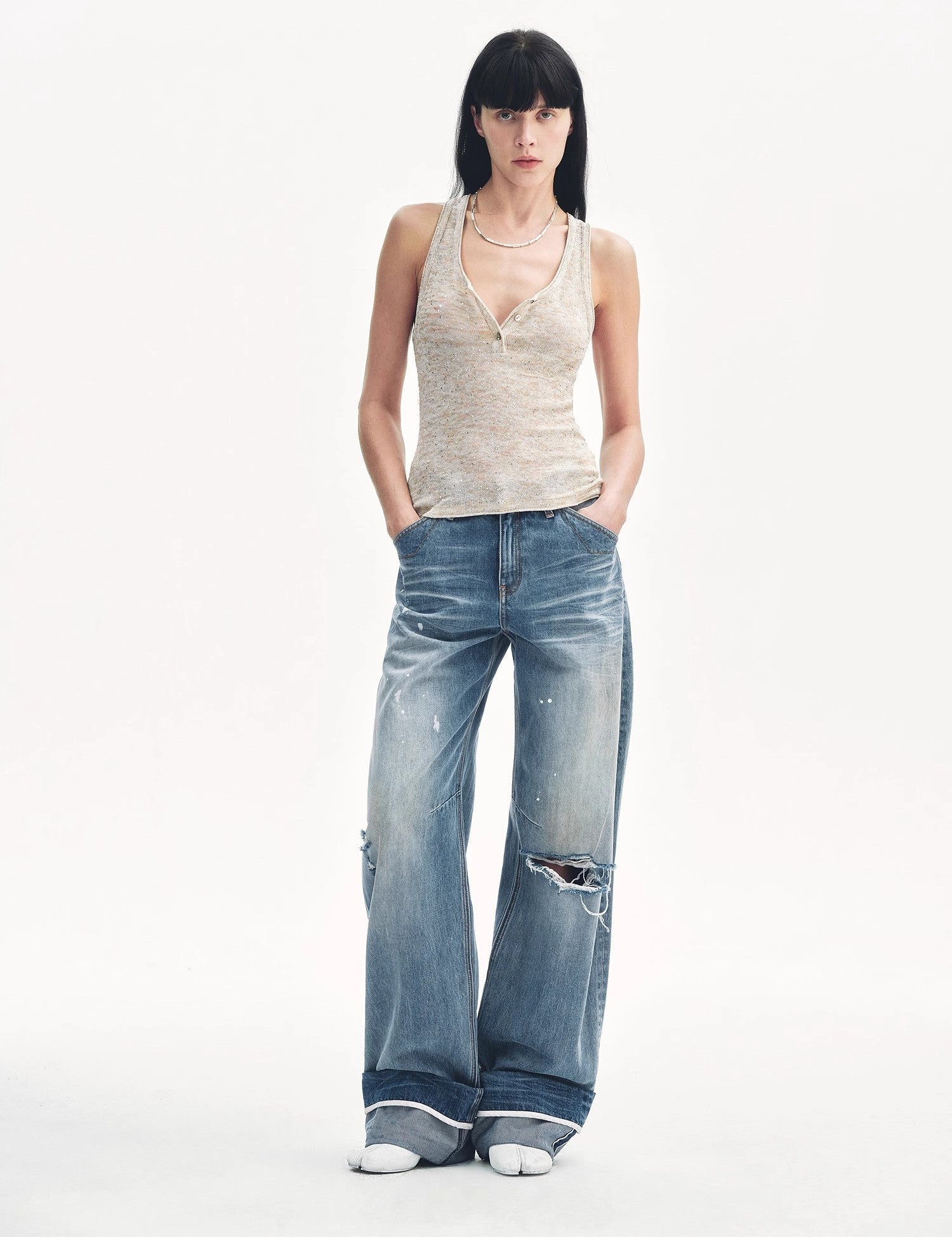 Model wearing Meredelle Sequin Henley Vest with gradient sequins and casual denim, showcasing a modern and stylish look.