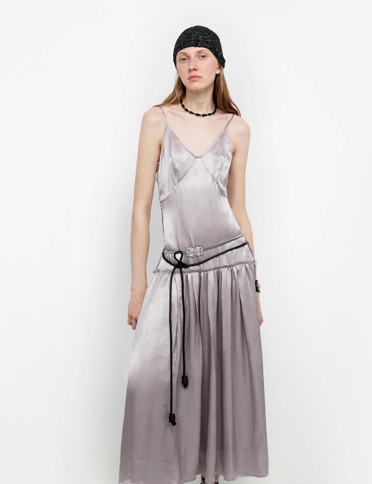 Woman wearing a Lowline Luxe Satin Dress with a deep V-neck and adjustable straps, featuring a rippled satin finish and low-waist cut.