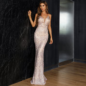 Elegant woman in champagne-hued strapless mesh gown with sequin details, perfect for red carpet and formal events.