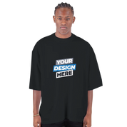 Model wearing black oversized drop-shoulder crewneck t-shirt with 'Your Design Here' text, streetwear style.