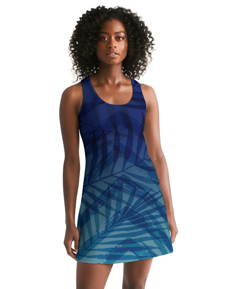 Woman wearing Sunset Hour Racerback Dress with blue leaf pattern, sleeveless design ideal for casual outings and summer evenings.