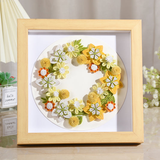 Handmade quilted paper garland in wooden frame, featuring floral design. Perfect for creative crafts and home decor.