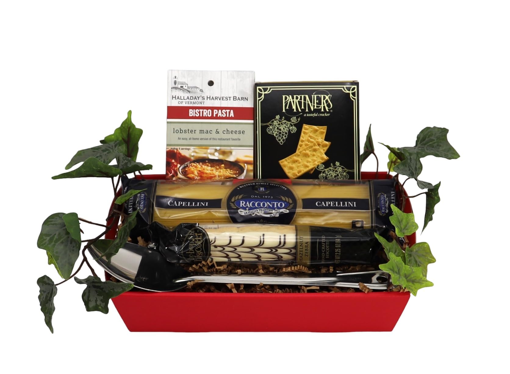 Italian gourmet gift tray with pasta, biscotti, and crackers in a red basket adorned with greenery.