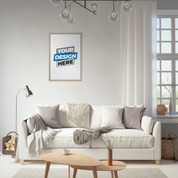 Stylish living room with a customizable framed canvas on the wall, featuring a cozy white sofa, pillows, and natural light.