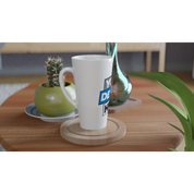 White 17oz ceramic latte mug with custom print design on wooden table, perfect for coffee or warm beverages, next to a plant and vase.