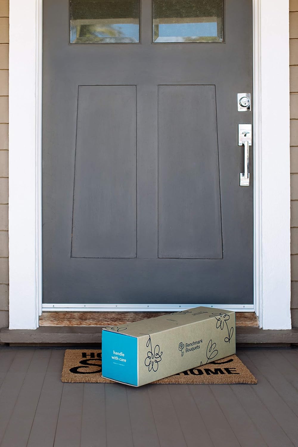 Delivery box on doormat at front door of a home.