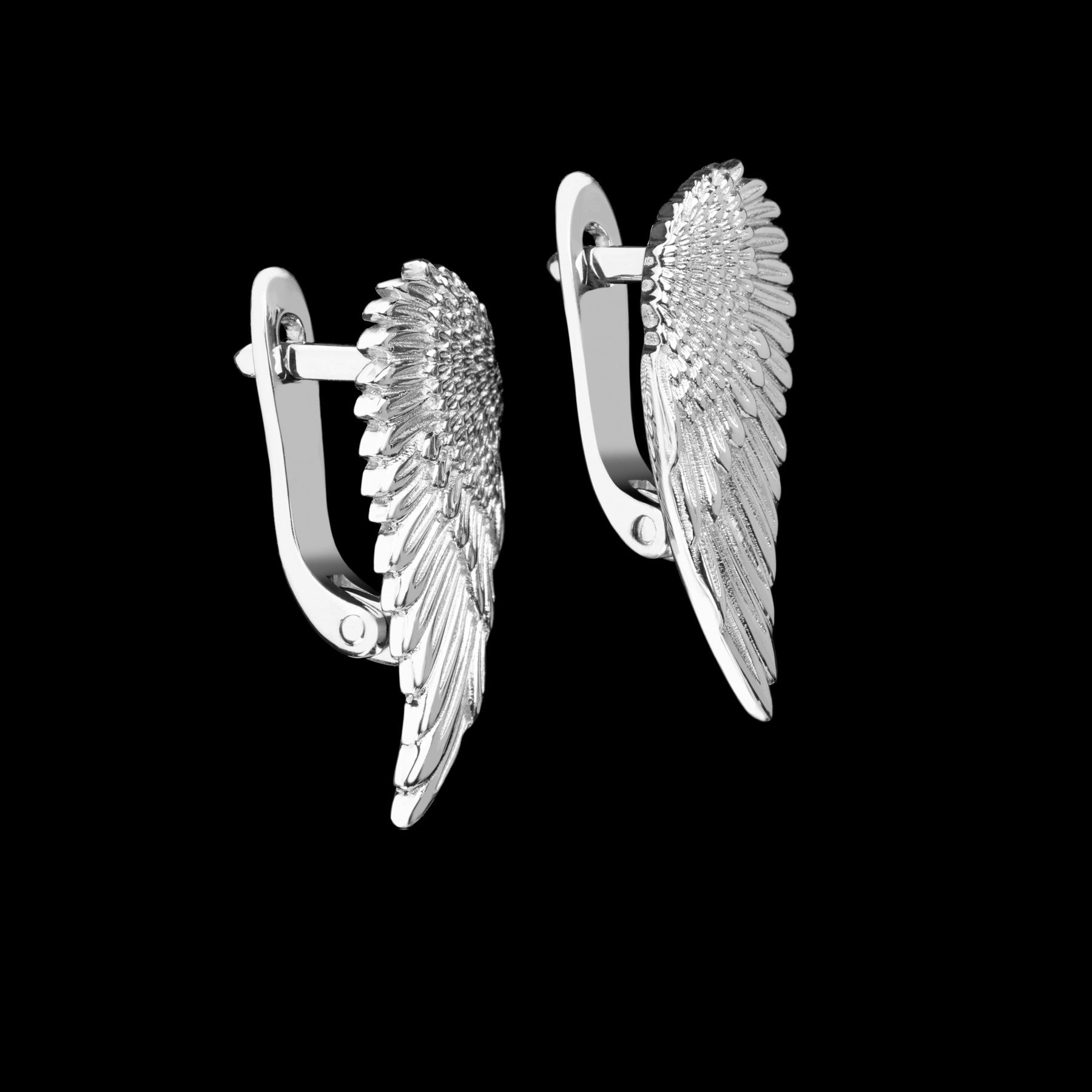 Sterling silver wing-shaped earrings "Regal Grace" with white rhodium finish and topazes on black background.