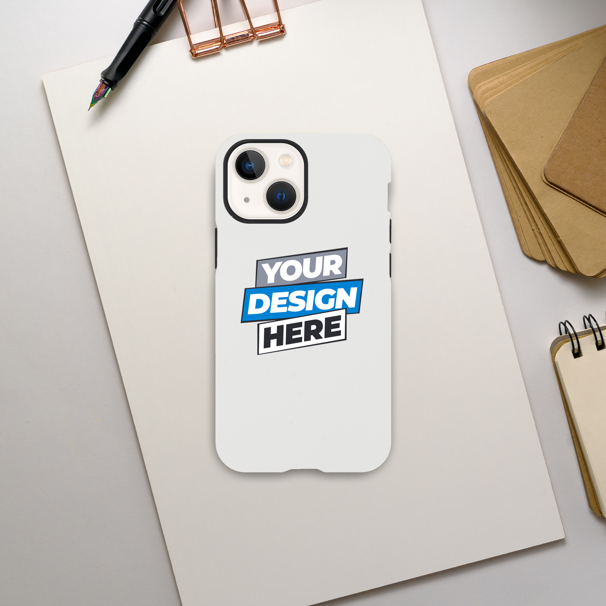 Gloss tough iPhone case with 'Your Design Here' on desktop. Durable, sleek, dual-layer protection. Wireless charging compatible.