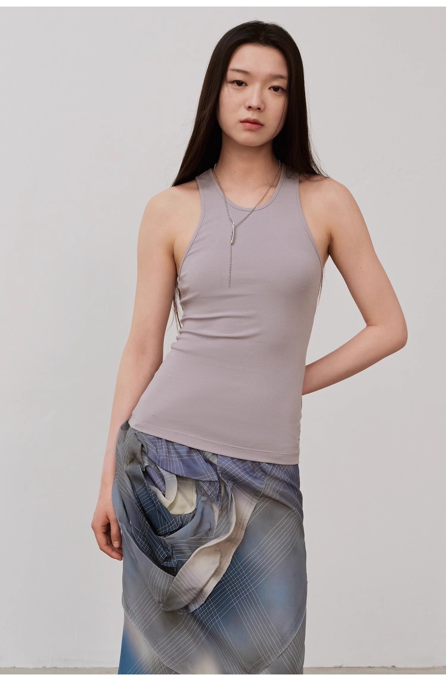 Woman wearing Isvera Slim Cotton Camisole in light gray, showcasing a flattering I-shaped neckline for a refined, elegant look.