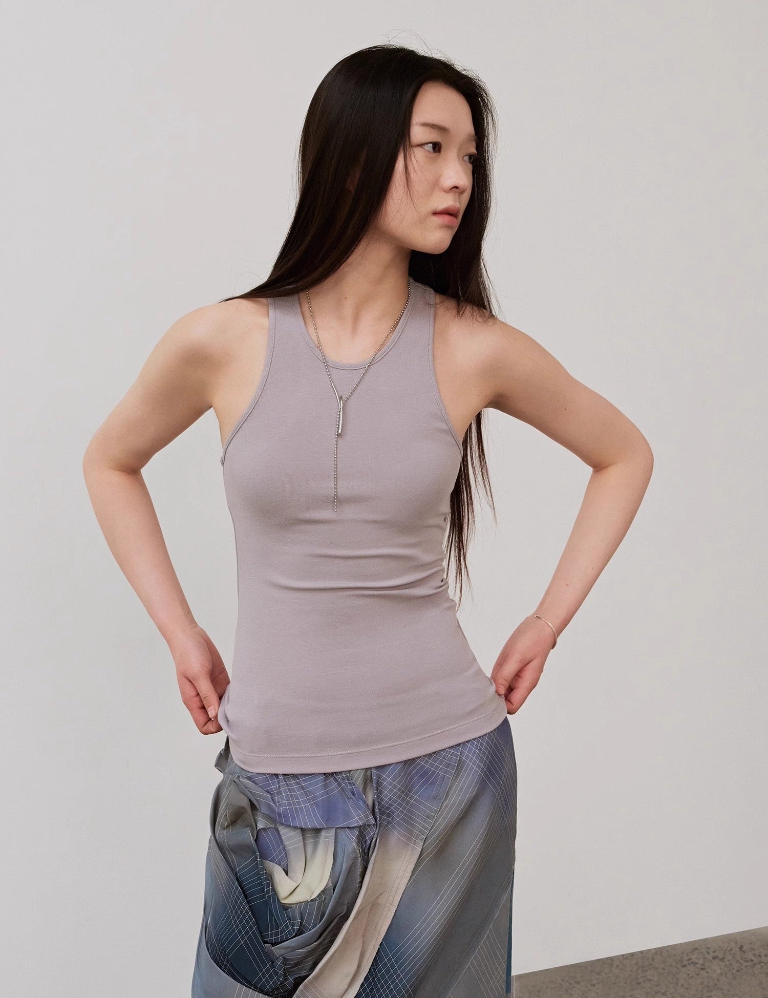 Woman wearing Isvera Slim Cotton Camisole, showcasing a stylish sleeveless fit with an I-shaped neckline for a modern, sleek look.