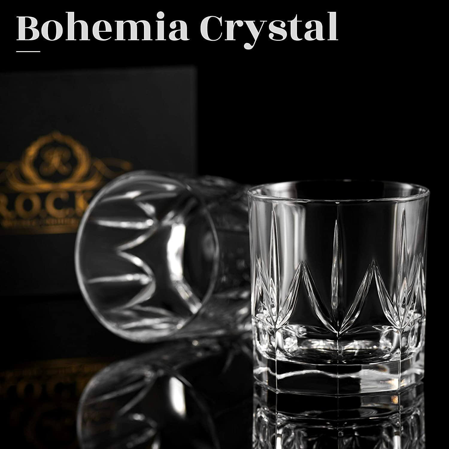 Two Bohemia Crystal whiskey glasses on a reflective surface, showcasing intricate cut designs and brilliant clarity against a black box.