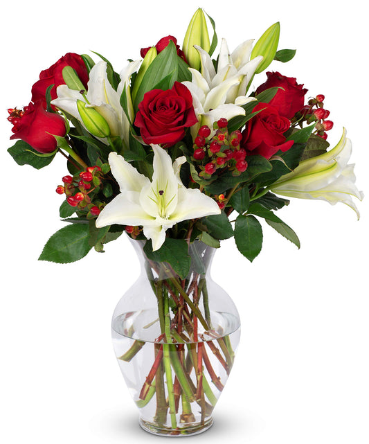 Red and white bouquet featuring roses, lilies, and hypericum in a glass vase, perfect for elegant occasions.