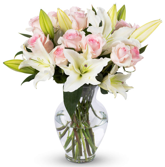 Elegant bouquet of pink roses and lilies in a glass vase, perfect for special occasions and showcasing sustainable beauty.