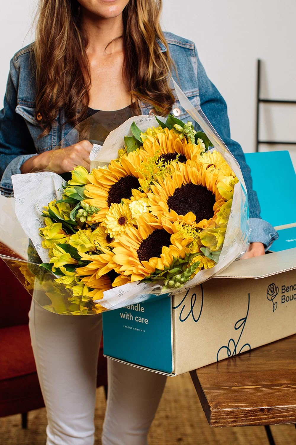 "Woman holding Rays of Sunshine Bouquet with sunflowers and snapdragons in a shipping box"