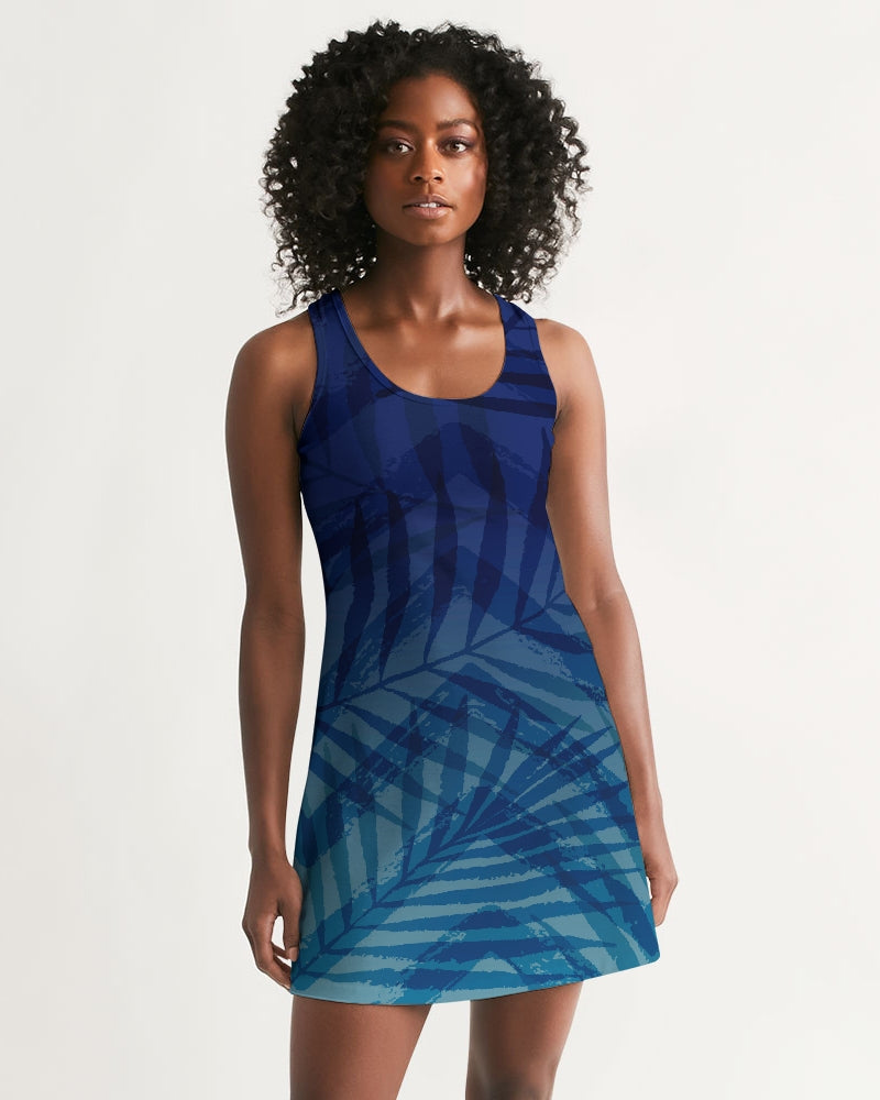 Woman wearing Sunset Hour Racerback Dress with blue leaf design, featuring a sleeveless cut and scoop neckline for a relaxed, breezy look.
