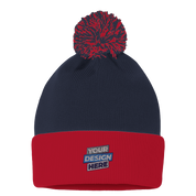 Navy and red knit pom beanie with custom embroidery design, featuring a playful pom-pom and fold-over cuff for adjustable fit.