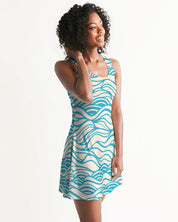 Woman wearing a Coastline Drift Racerback Dress with blue wave pattern, scoop neckline, and above-knee length, ideal for warm days.