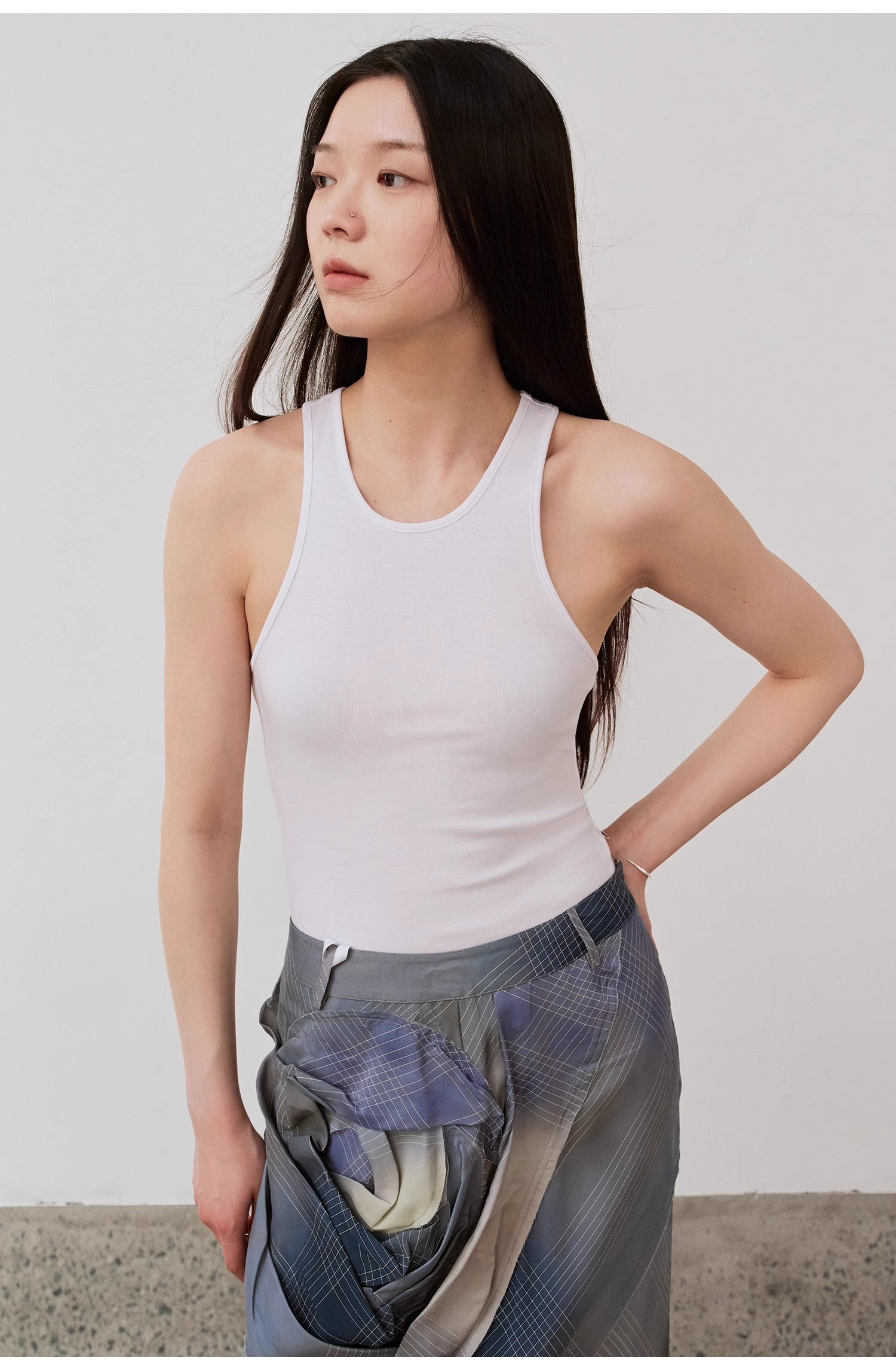 Woman wearing Isvera Slim Cotton Camisole, showcasing a fitted design with an elegant I-shaped neckline, perfect for summer wear.