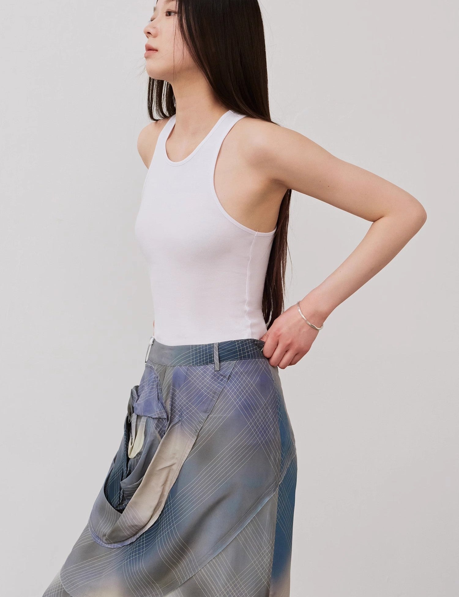 Woman wearing Isvera Slim Cotton Camisole with I-shaped neckline, styled with a flowing patterned skirt for a chic summer look.