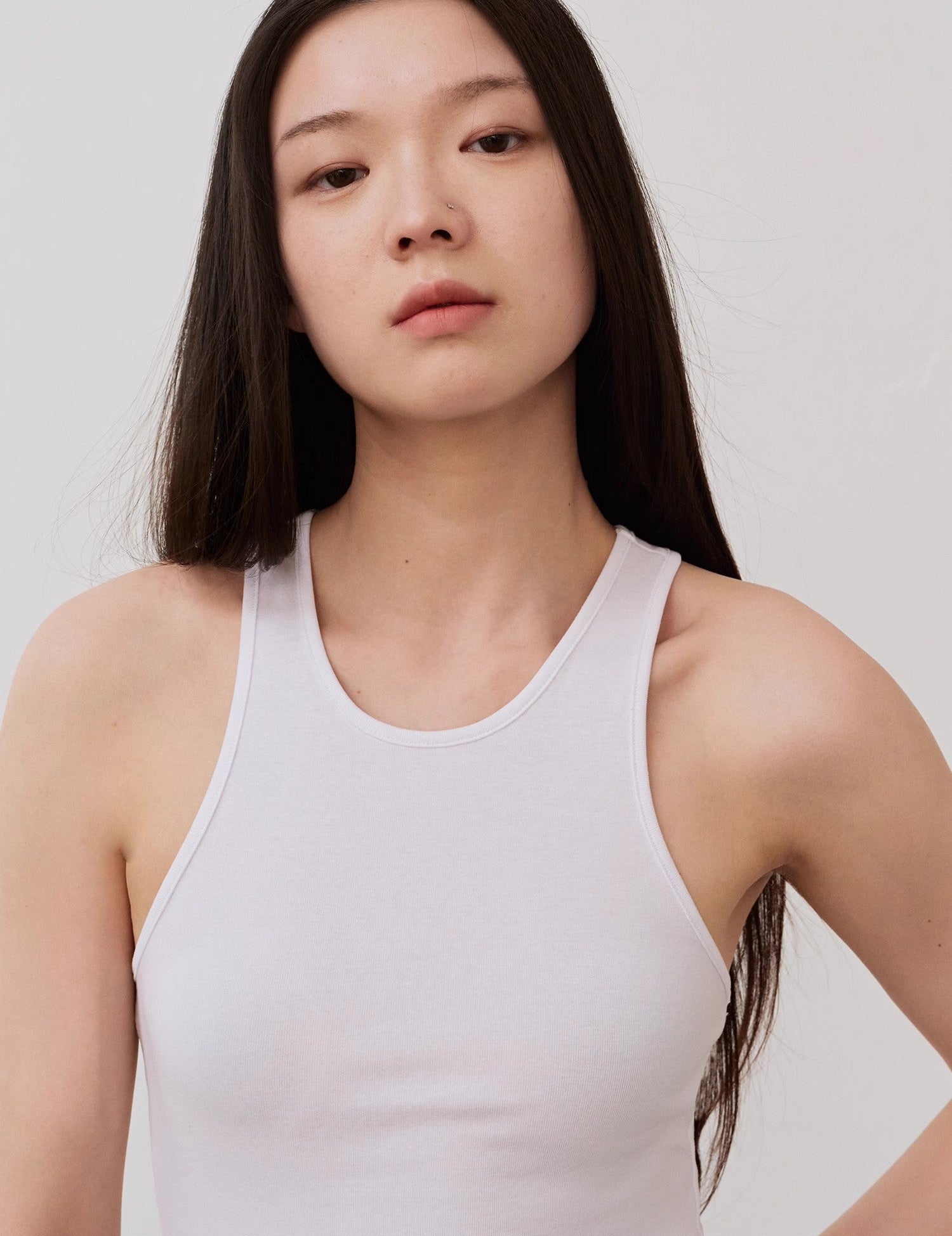 Woman wearing Isvera Slim Cotton Camisole showcasing its breathable, slim fit and I-shaped neckline.